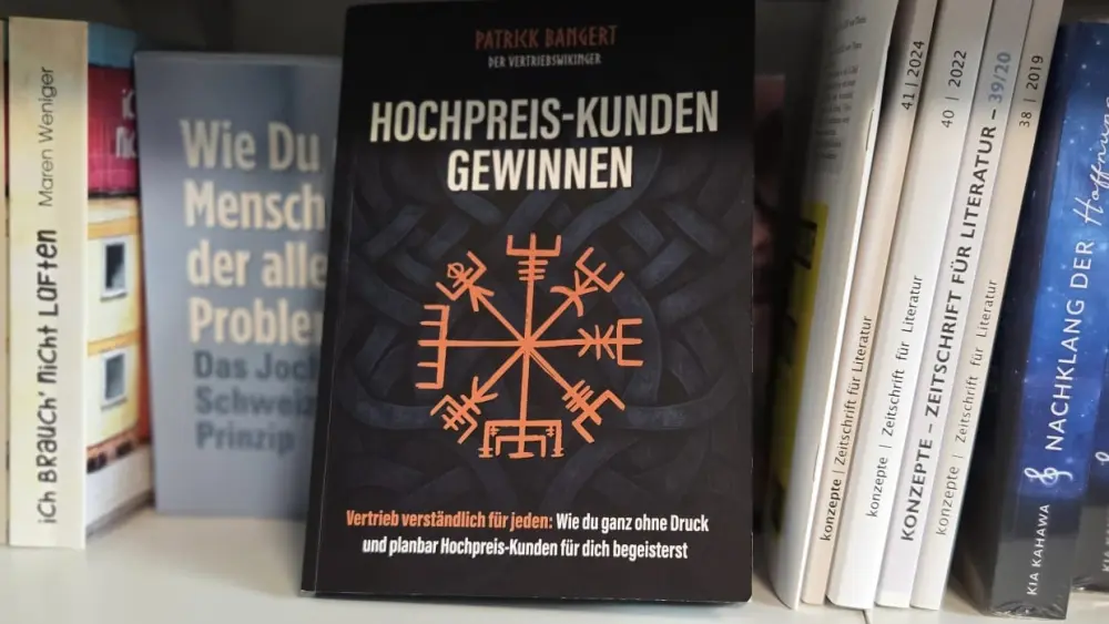 Das Buch 'Hochpreis-Kunden gewinnen' steht in einem Regal.