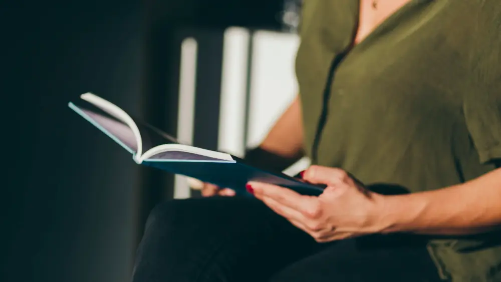 Eine Person liest ein Buch, um die Qualität professionelles Selfpublishing zu prüfen.