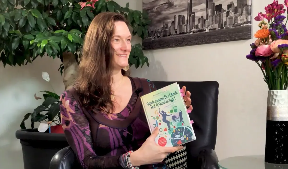 Autorin zeigt ihr eigenes Buch zum Thema 'Eigenes Buch schreiben'.