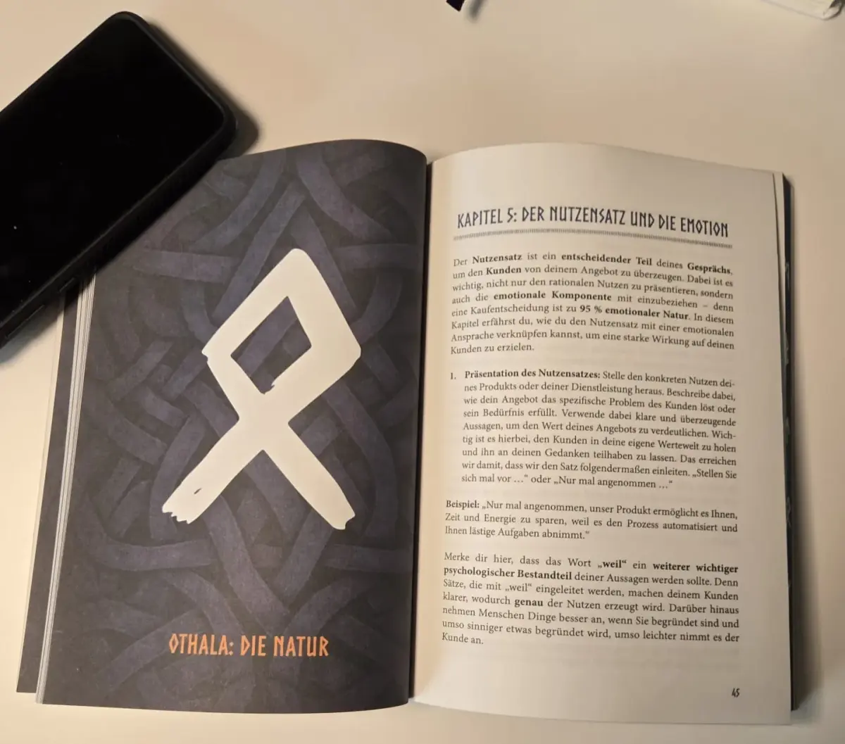 Aufgeschlagenes Expertenbuch über Akquise mit künstlerischem Design.