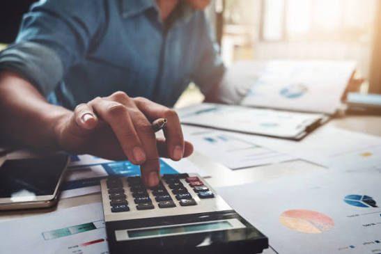 Eine Person analysiert Finanzfehler beim Autokauf mit einem Taschenrechner.