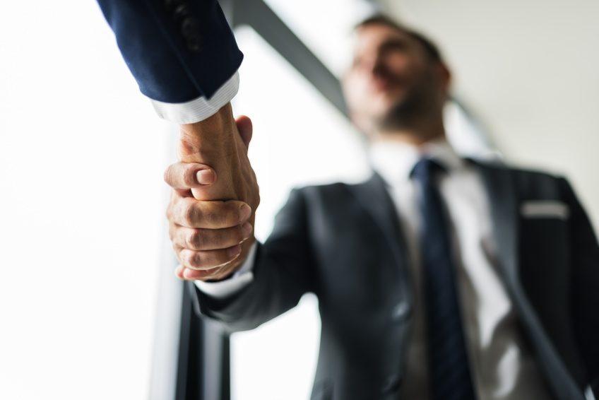 Händedruck zwischen zwei Männern, symbolisiert Neo-Broker und Zusammenarbeit.