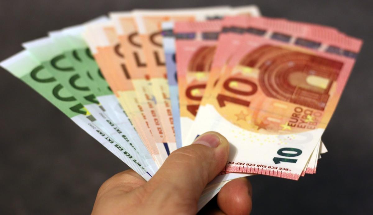 Hand hält verschiedene Geldscheine, wichtig für ETFs steuerfrei investieren.