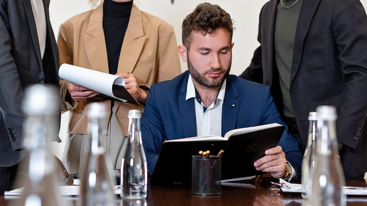 Ein Geschäftsführer analysiert Unterlagen während der GKV Reform 2027 Sitzung.