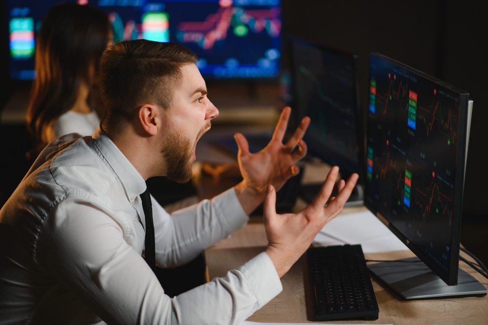Mann reagiert emotional beim Trading während eines Börsencrashs.