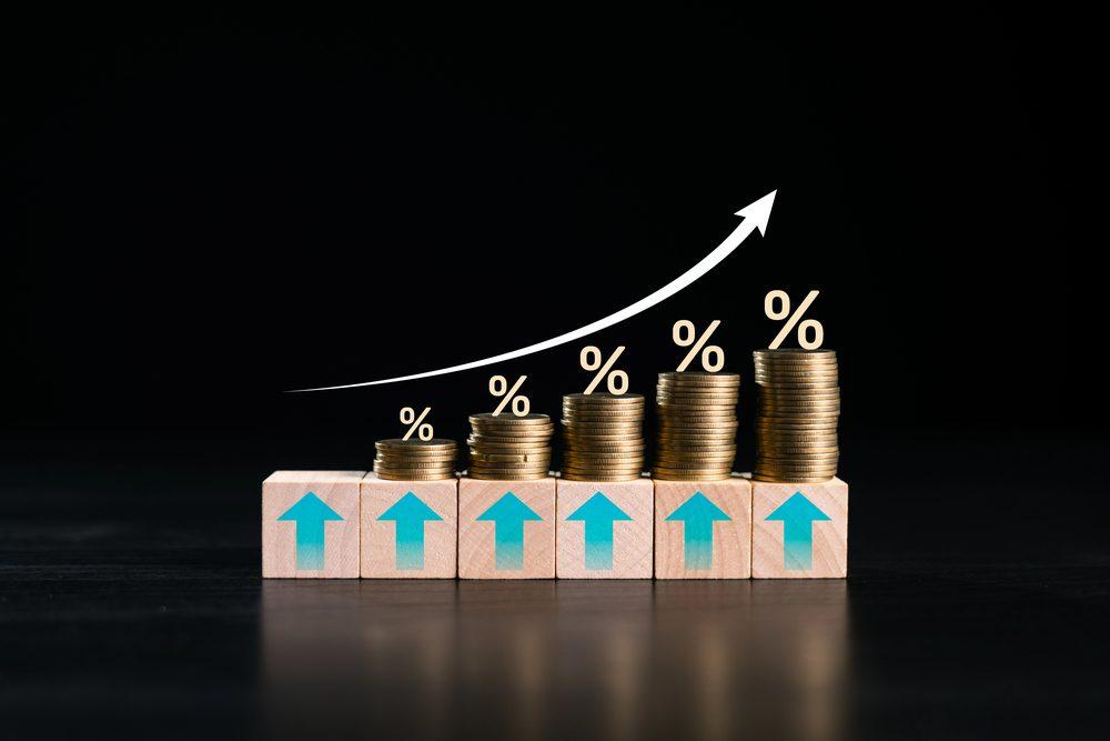 Grafik zeigt Wachstum von Münzstapeln mit Prozentzeichen, um Risikomanagement im Trading darzustellen.