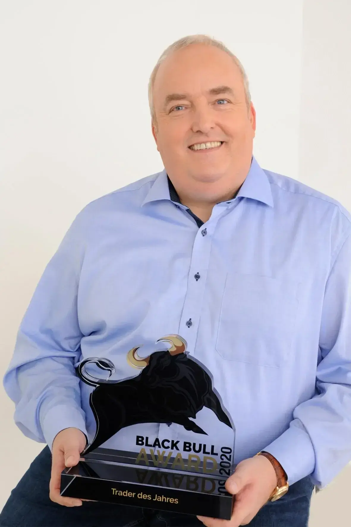 Mario Lüddemann zeigt stolz seinen Black Bull Award als Trader des Jahres.