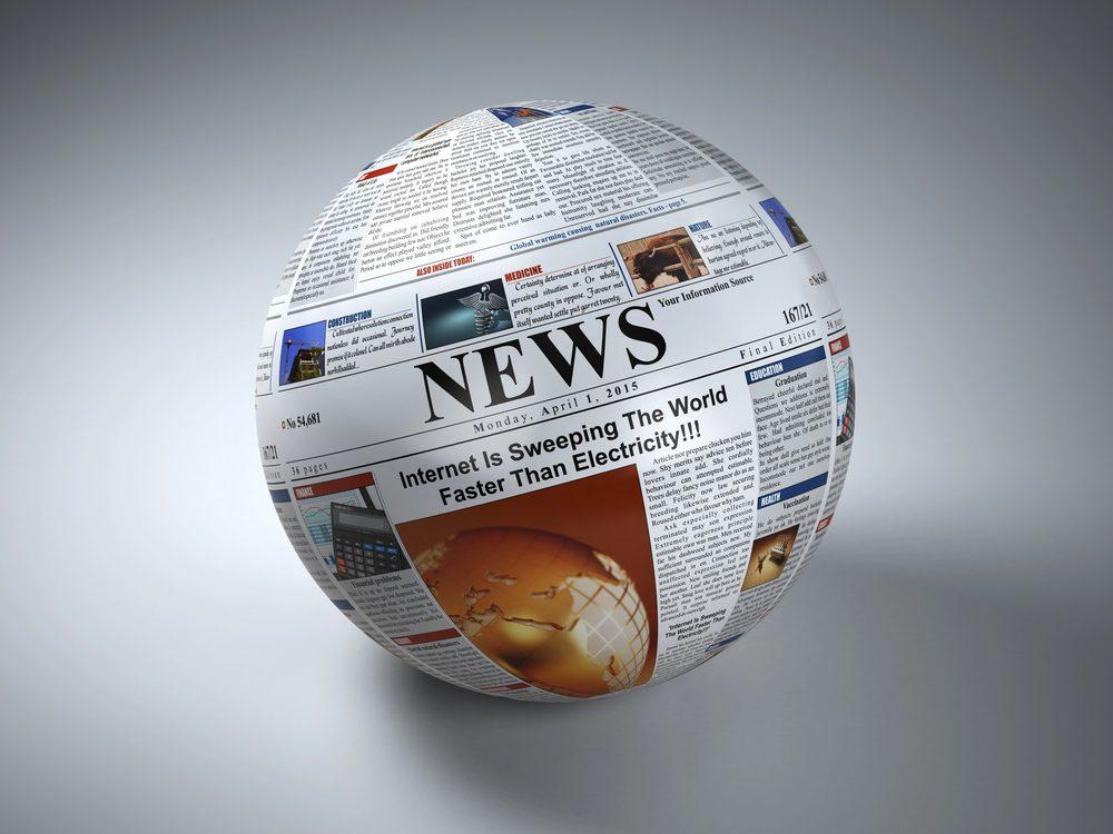 Globus aus Zeitungen mit der Aufschrift News im Newstrading Kontext.