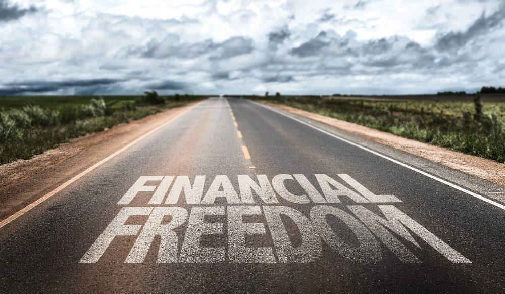 Eine Straße mit dem Schriftzug 'finanzielle freiheit', die in den Horizont führt.