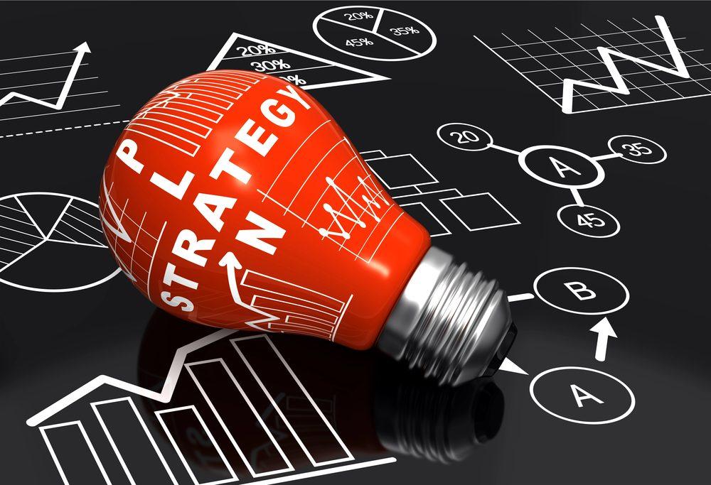 Eine rote Glühbirne mit dem Wort Strategie, die das Thema Trading ohne Plan symbolisiert.