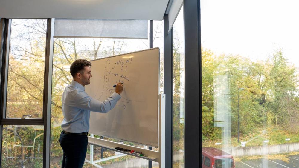 Ein Mann erklärt die Effektstärke an einem Whiteboard während einer Präsentation.