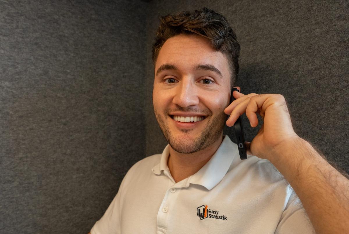 Mann in einem Telefonat, lächelnd während der Analyse von Längsschnittstudien.