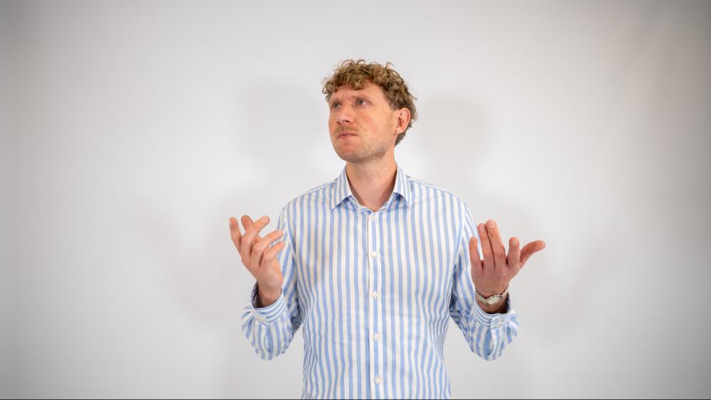 Mann mit Händezeichen über die Statistiksoftware vergleichen.