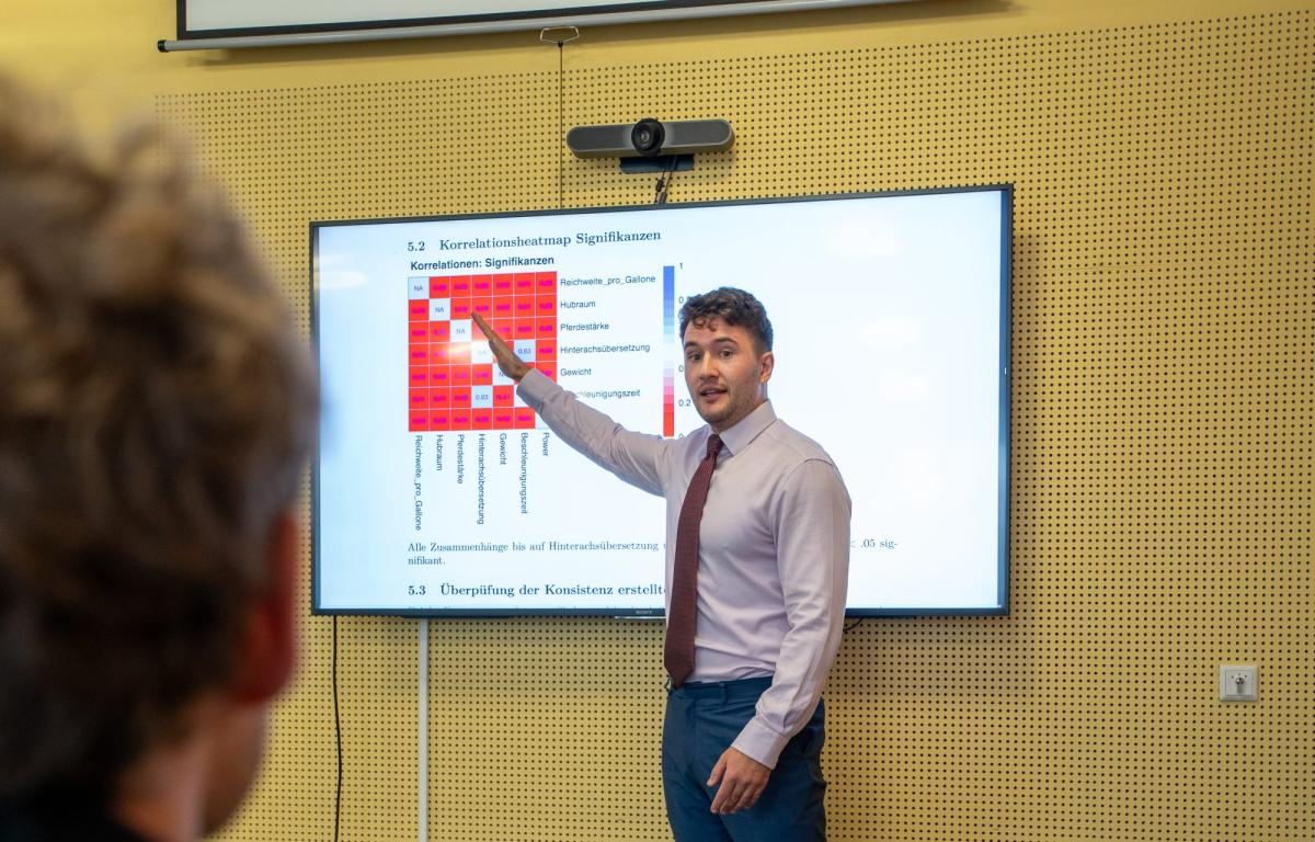 Ein Referent erklärt mit einer Grafik zur Zeitreihenanalyse von Finanzdaten.