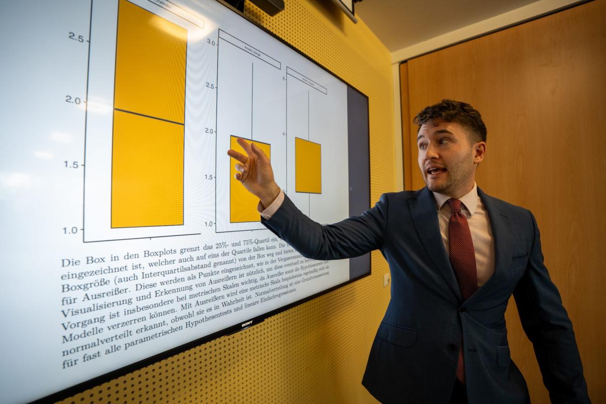 Ein Mann erklärt ein Diagramm mit Odds Ratios während einer Präsentation.
