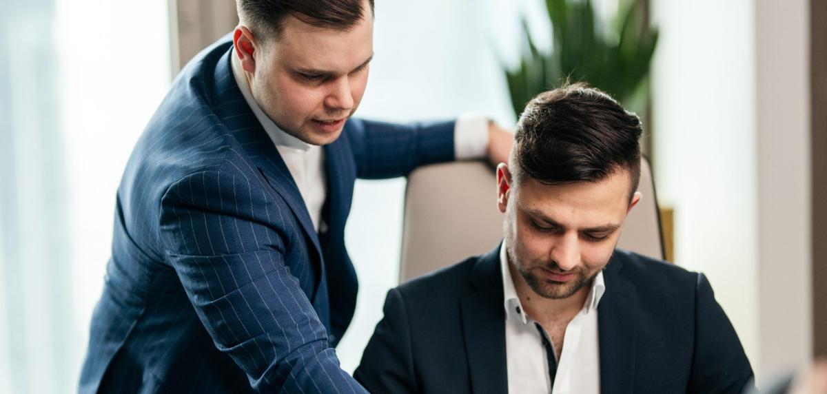 Zwei Personen diskutieren die Gebäudeversicherung für Hausverwaltungen.