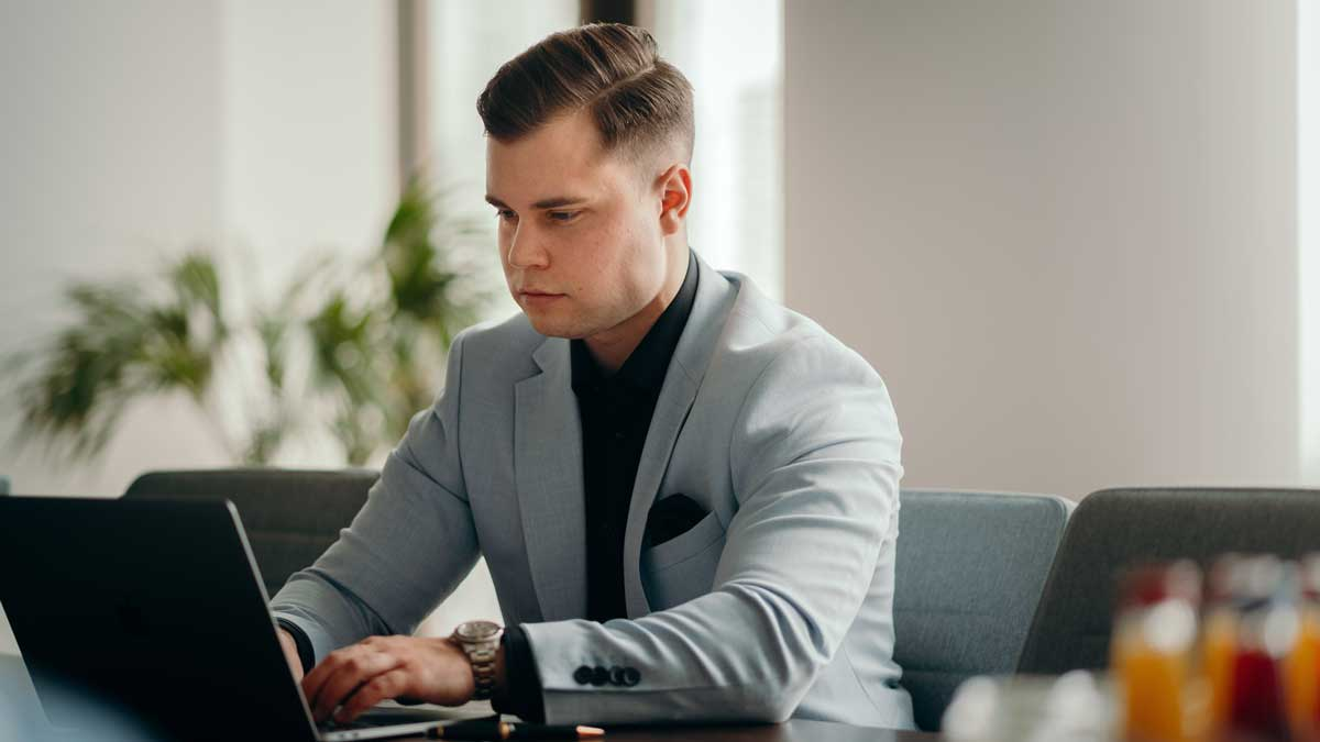 Mann arbeitet konzentriert am Laptop zur D&O-Versicherung bei Insolvenz.