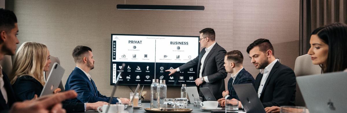 Eine Gruppe von Geschäftsleuten diskutiert Aktien-Investments über eine Holding in einer Präsentation.