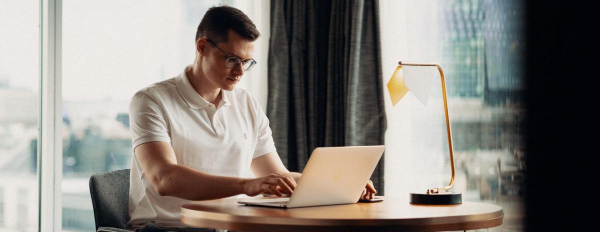 Ein Selbstständiger arbeitet am Laptop während des PKV-Wechsels.