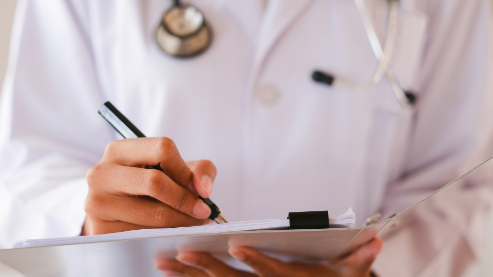 Ein Arzt macht Notizen zu Veränderungen der Gesundheitsreform.