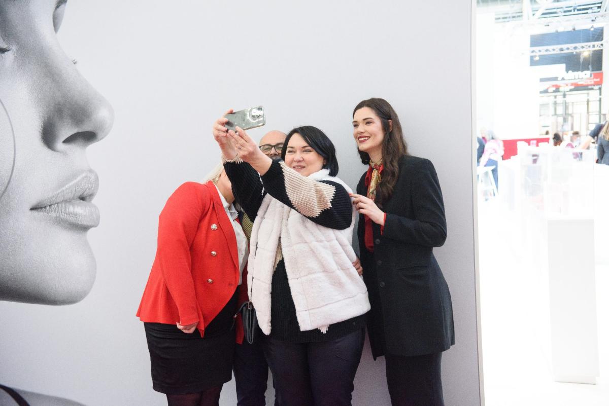 Drei Frauen machen ein Selfie während einer Beauty Business Consulting Veranstaltung.
