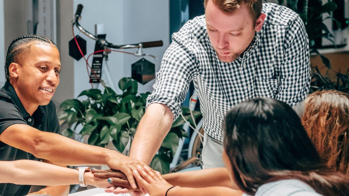 Teamarbeit am Tisch zur Verbesserung des CRMs mit strukturierter Vorgehensweise.