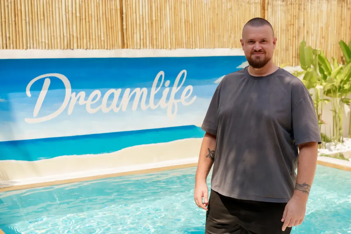 Mann steht am Pool vor dem Schriftzug Dreamlife, Social Recruiting Thema.