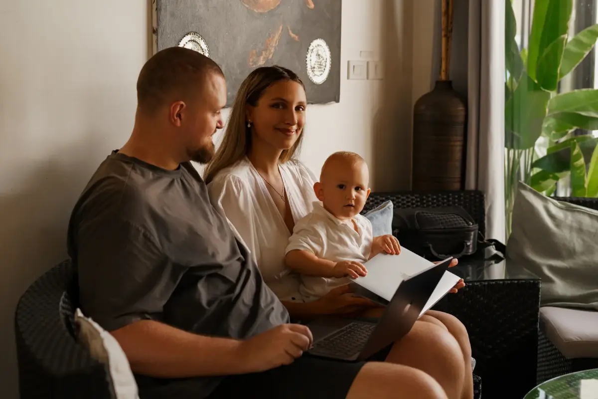 Familie mit Kind schaut auf einen Laptop und diskutiert Social Recruiting.