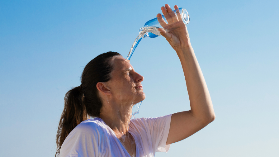 Frau gießt sich Wasser über das Gesicht, die Waage zeigt mehr an.