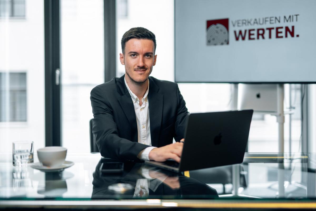 Mann sitzt am Schreibtisch mit Laptop, zeigt LinkedIn Potenzial.