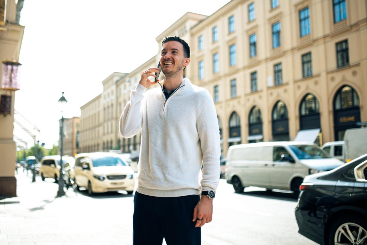 Mann in weißer Jacke telefoniert und steht auf der Straße für CEO Content.