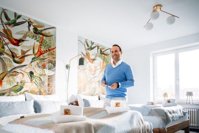 Ein Gastgeber präsentiert professionelle Fotos für Ferienwohnungen in einem stilvollen Raum.