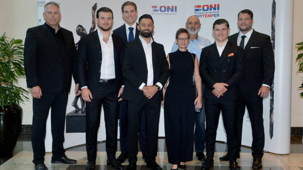 Das Team der Bedachungen Schmidt bei einer Auszeichnung in eleganter Kleidung.