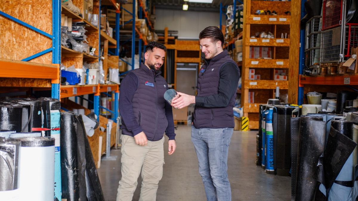 Zwei Mitarbeiter im Lager besprechen die Photovoltaik Planung.