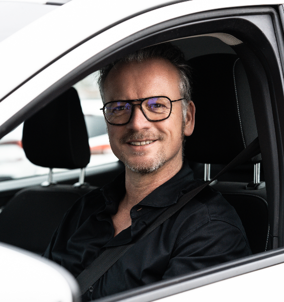 Mann im Auto, der für unabhängiges PV-Gutachten lächelt.