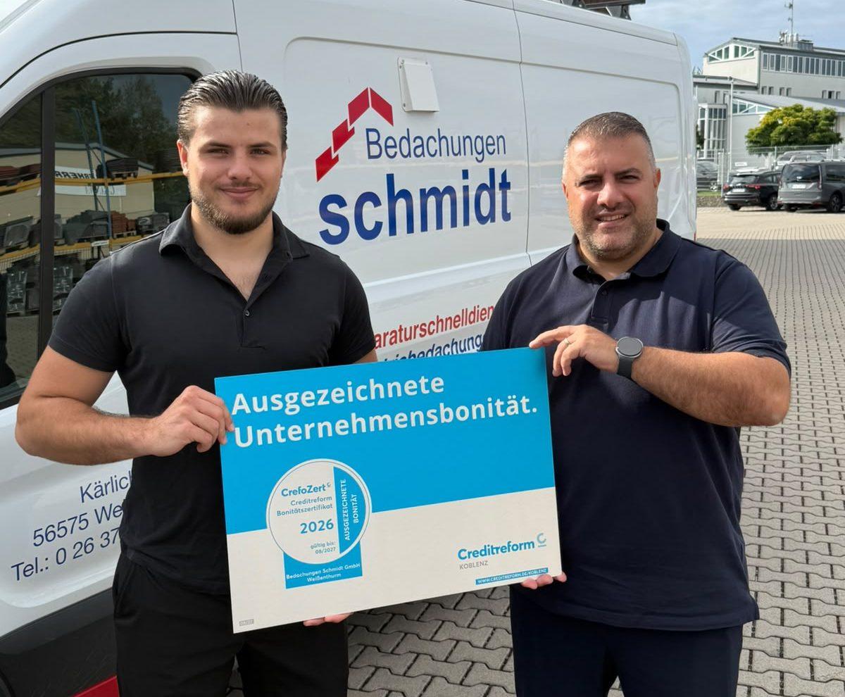 Zwei Männer halten stolz das CrefoZert für ausgezeichnete Unternehmensbonität hoch.