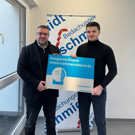 Zwei Männer präsentieren das CrefoZert zur ausgezeichneten Unternehmensbonität.
