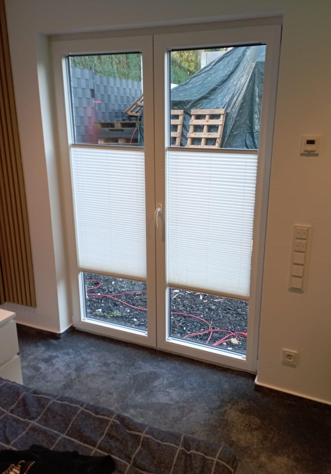 Ein Fenster mit Plissees als Sicht- und Sonnenschutz im Raum.