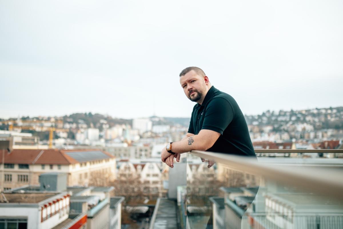 Ein Mann lehnt an einem Geländer und blickt auf die Stadt, was die faire Reklamationslogik symbolisiert.