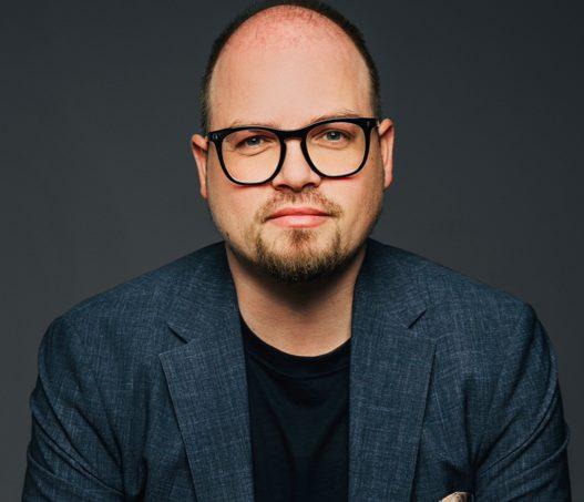 Porträt eines externen CFO mit Brille in einem Blazer.