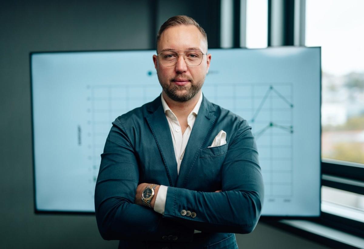 Mann mit verschränkten Armen vor Präsentation zu Immobilien Einsteiger Fehler.