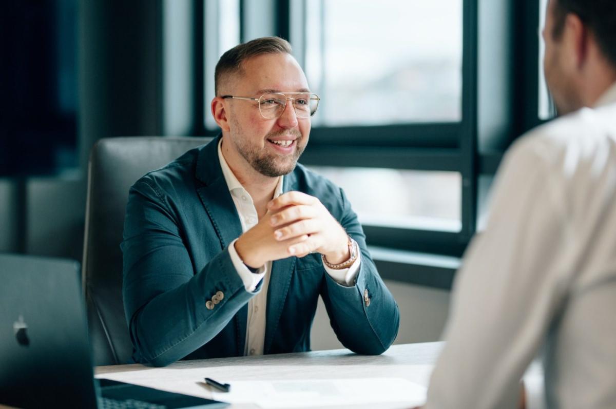 Ein Mann diskutiert über Immobilien als Anlageklasse während eines Beratungsgesprächs.
