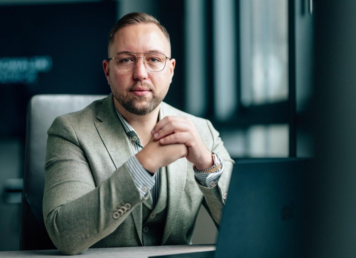 Mann im Anzug sitzt im Büro und diskutiert über Vermieter oder Investor.