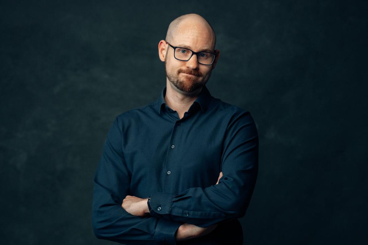 Ein Gutachter mit verschränkten Armen zeigt, wie wichtig wirksames Marketing ist.