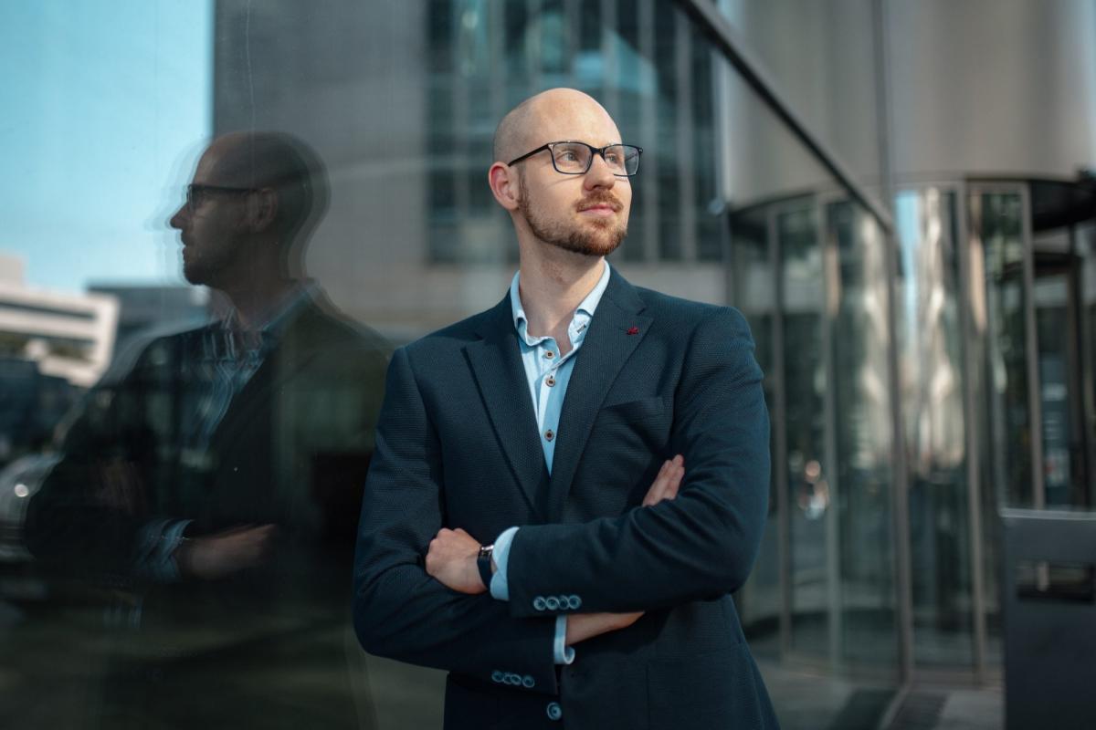 Ein Experte für Sichtbarkeit im Marketing steht nachdenklich vor einer Glasfront.