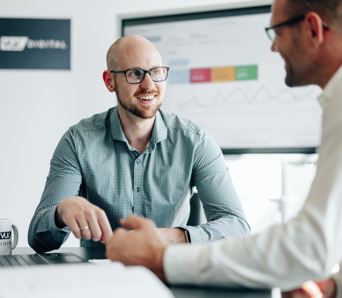 Zwei Männer im Beratungsgespräch zur Zielgruppendefinition im Marketing.