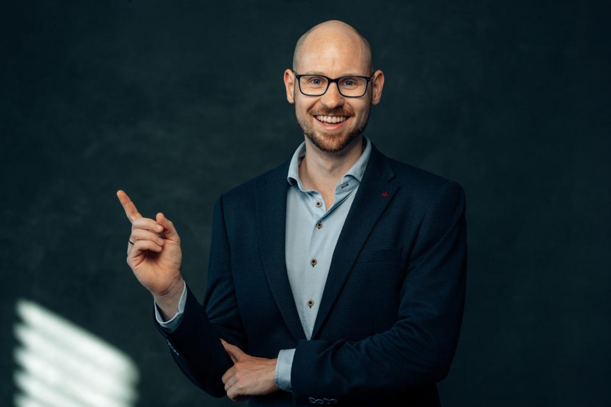 Ein Fachmann gestikuliert und spricht motiviert über die Überwindung von Experten-Arroganz.