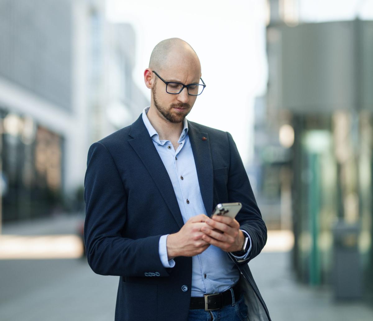 Junger Gutachter nutzt sein Smartphone für Social Media Aktivitäten.
