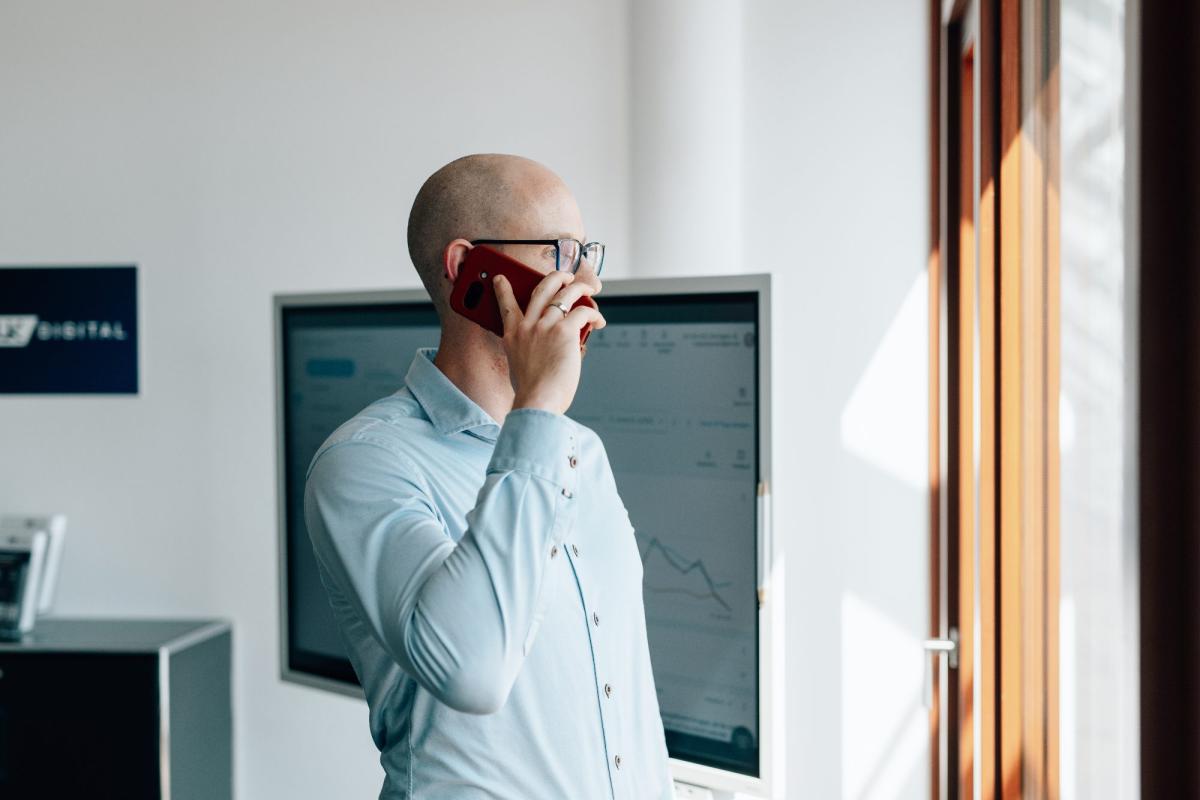 Mann am Telefon in einem modernen Sachverständigenbüro zur Planungssicherheit.