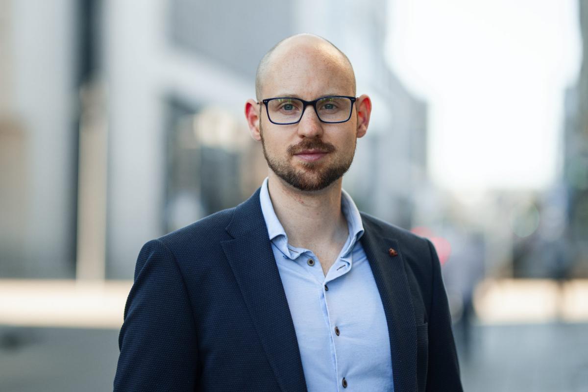 Businessmann in Anzug auf der Straße zeigt Selbstbewusstsein für Honorare als Sachverständiger.